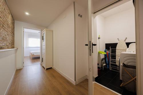 a hallway with a door and a brick wall at Atico duplex Playa Area barcelona con SPA exterior in Montgat