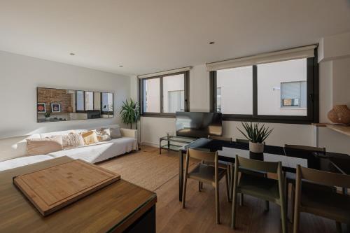 uma sala de estar com um sofá e uma mesa em Atico duplex Playa Area barcelona con SPA exterior em Montgat