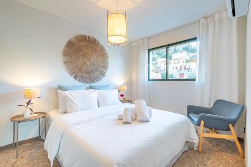 1 dormitorio con 1 cama blanca y 1 silla azul en Marsella, en Puerto de Sóller