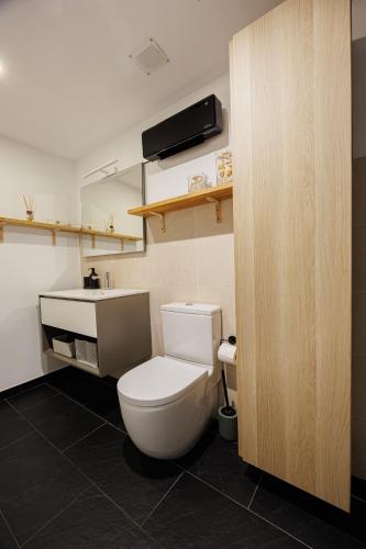 a bathroom with a white toilet and a sink at Atico duplex Playa Area barcelona con SPA exterior in Montgat