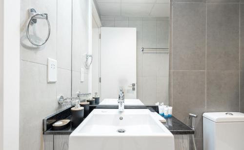 a bathroom with a white sink and a toilet at SuperHost - Comfort 1BR Centurion Onyx Retreat with Balcony in Dubai