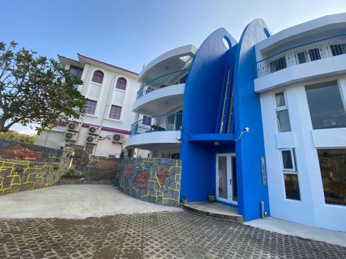 a blue and white building with a tree in front at 迦那會館 in Eluan