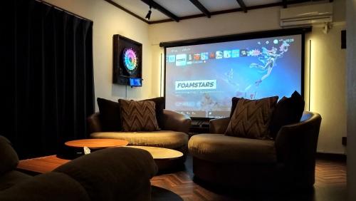 a living room with two chairs and a projection screen at Cinema Resorts 1 in Motobu