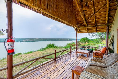 a porch with chairs and a view of a lake at Mweya Safari Lodge in Katwe