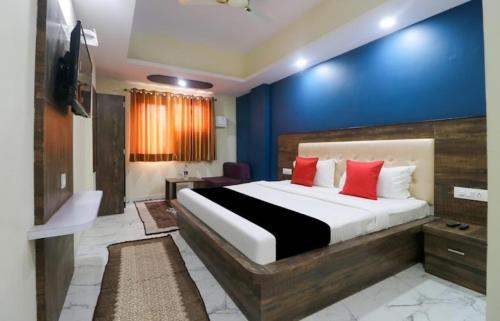 a bedroom with a large bed with red pillows at hotel nanda inn in Haridwār