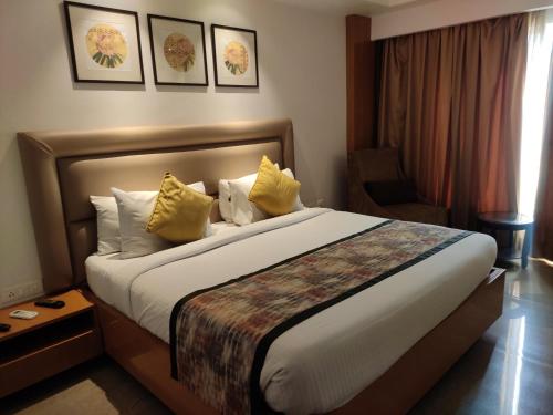 a hotel room with a large bed with yellow pillows at hotel nanda inn in Haridwār