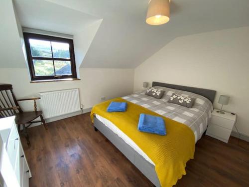 Traditional Welsh cottage in Llanberis في لانبيريس: غرفة نوم بسرير كبير عليها مناشف زرقاء
