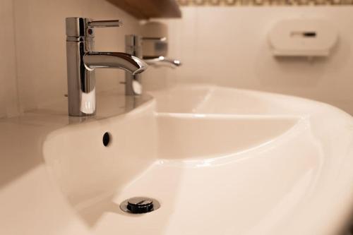a white sink with a faucet in a bathroom at Suite 1 - Krems an der Donau in Rossatz