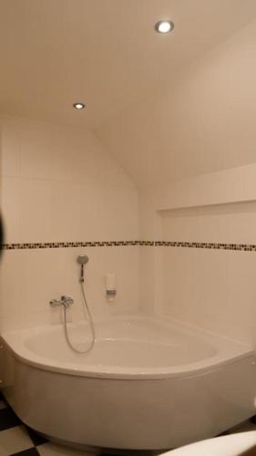 a white bath tub in a bathroom with a tile floor at Suite 1 - Krems an der Donau in Rossatz