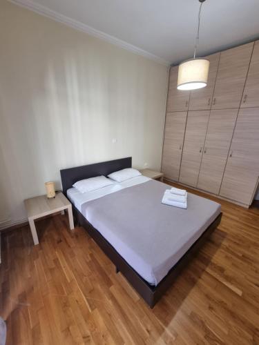 a bedroom with a large bed and wooden floors at athens.apartotel.3 in Athens