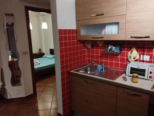 eine Küche mit einer Spüle und roten Fliesen in der Unterkunft Smart Apartment by the Sea near Palermo, Sicily in Isola delle Femmine