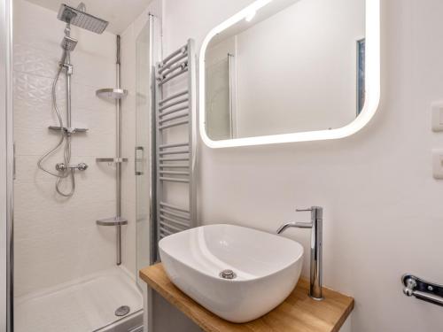 une salle de bain blanche avec un lavabo et un miroir dans l'établissement Joli studio rue de Nazareth, à Paris