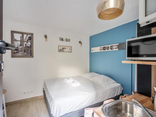 Cette petite chambre comprend un lit et un lavabo. dans l'établissement Joli studio rue de Nazareth, à Paris
