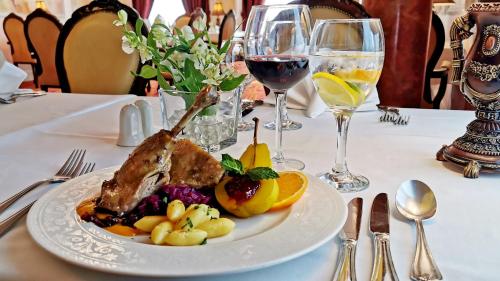 a plate of food on a table with wine glasses at Pałacyk Otrębusy Business & Spa in Otrębusy