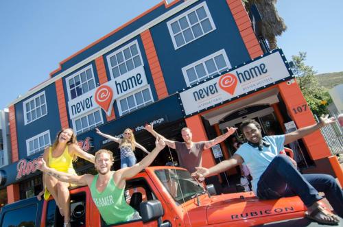 Un gruppo di persone seduto sul retro di un camion di Never at Home Green Point a Città del Capo