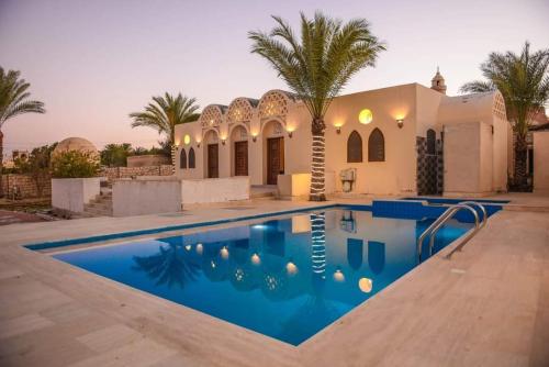 a villa with a swimming pool in front of a house at Sun house in Tunis