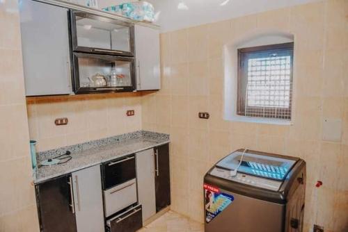 a small kitchen with a counter and a refrigerator at Sun house in Tunis