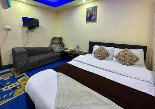 um quarto com uma cama e um urso de peluche numa cadeira em Hotel Yog Darshan em Kathmandu