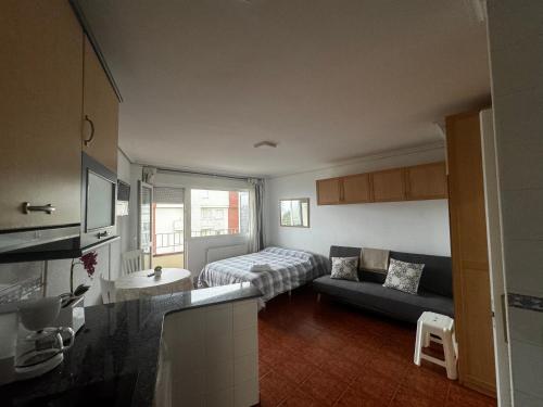 a small living room with a couch and a bed at Apartamento con vistas al mar y piscina II in Suances