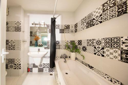 a bathroom with black and white tiles on the wall at Vintage Boutique Hotel & Spa in Ho Chi Minh City