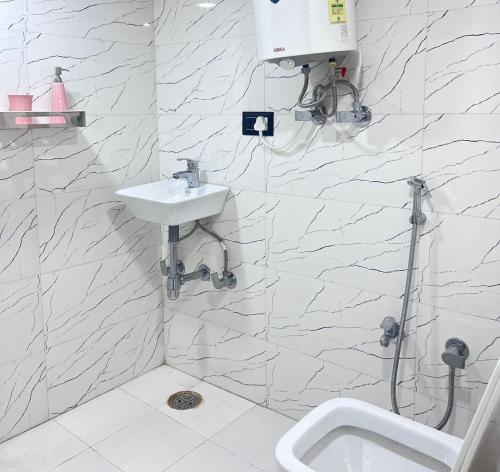 een witte badkamer met een wastafel en een douche bij 3 Raahi in Udaipur