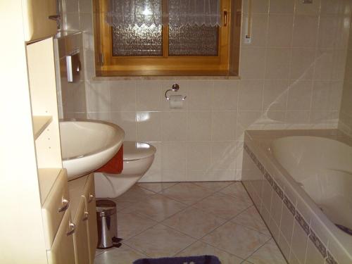 a bathroom with a sink and a toilet and a tub at Ferienwohnung Reisinger in Arnbruck