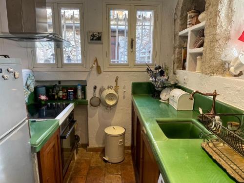 una cucina con piano di lavoro verde e lavandino di Ma Maison a Vence