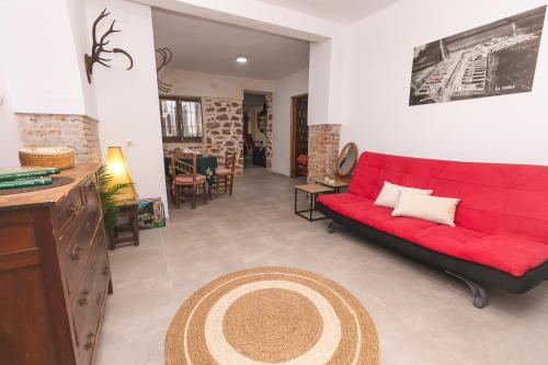 a living room with a red couch and a rug at La Tejuela - Casa en Andújar independiente con piscina in Los Villares
