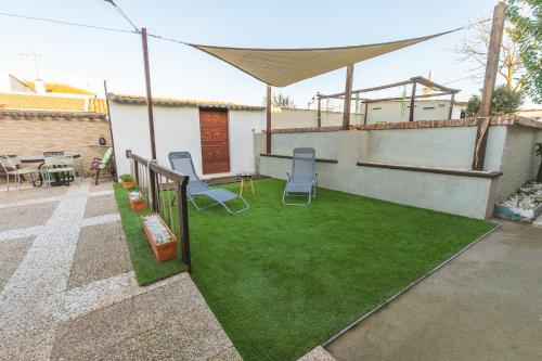 a backyard with a lawn with chairs and a tent at La Tejuela - Casa en Andújar independiente con piscina in Los Villares