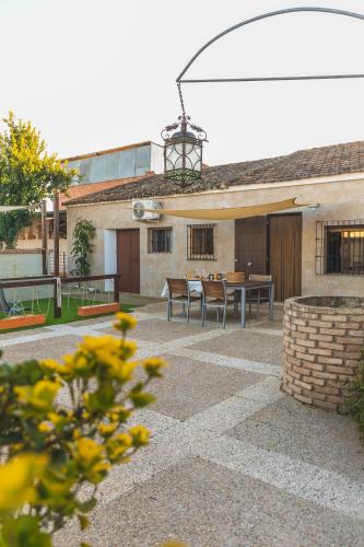 a patio with a table and chairs in front of a building at La Tejuela - Casa en Andújar independiente con piscina in Los Villares