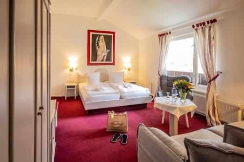 a hotel room with a bed and a couch at Meeressterne Hotel Weißes Schloß in Heringsdorf