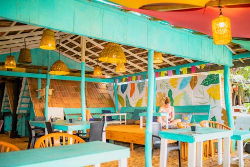 une femme assise à une table dans un restaurant dans l'établissement Smile Beach Home, à Galle