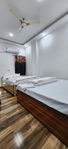 2 łóżka w pokoju z drewnianą podłogą i sufitem w obiekcie Pitambara Dham w mieście Wryndawan