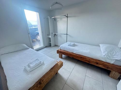 um quarto com 2 camas e uma porta de vidro deslizante em Grand appartement proche de Délemont avec terrasse by Stay Swiss 