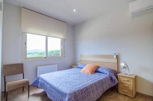 Un dormitorio con una cama azul y una ventana en Villa Barbie, en Lloret de Mar