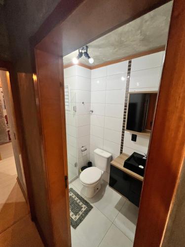 a bathroom with a toilet and a television in it at Apartamento Centro Venâncio Aires in Venâncio Aires