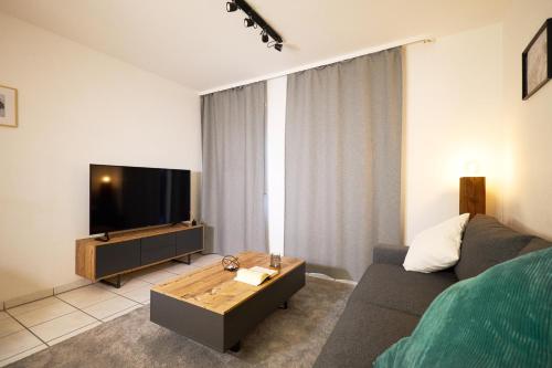 a living room with a couch and a flat screen tv at Gemütliche 2Zi. Wohnung in Seligenstadt