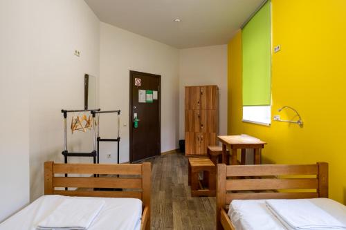two beds in a room with yellow and green walls at DREAM Hostel Kyiv in Kyiv