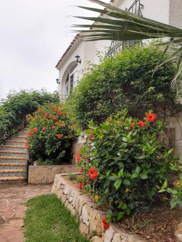 a house with a staircase and flowers in front of it at Villa Adriana v rezidencii Toscamar in Jávea