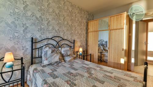 une chambre avec un lit et une peinture murale dans l'établissement Vue sur l'horizon au Constellation, à Saint-Hilaire-de-Riez