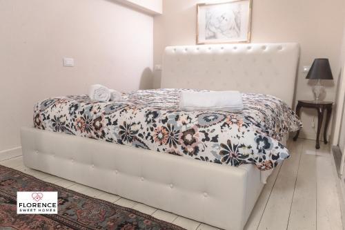 1 cama en un dormitorio con marco de cama blanco en Matteotti Apartment en Scandicci