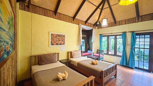 Villa Bali Eco Resort, Rayong في رايونغ: غرفة بسريرين في غرفة