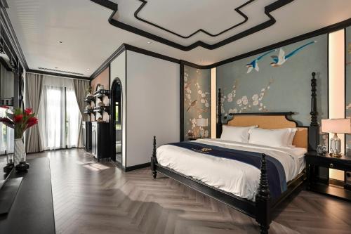 a bedroom with a large bed with a ceiling at Thiên Ân Boutique Hotel in Bạc Liêu
