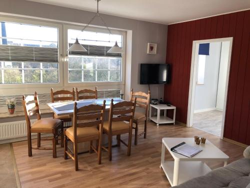 a dining room with a table and chairs and a tv at Marbijes Appartementhaus in Cuxhaven