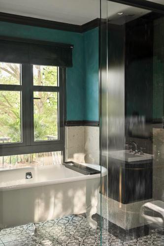 a bathroom with a bath tub and a window at Thiên Ân Boutique Hotel in Bạc Liêu
