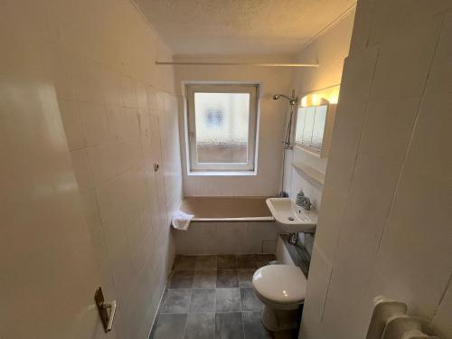 a bathroom with a tub and a toilet and a sink at Zweckmäßige Monteurwohnung nahe Innenstadt in Neumünster