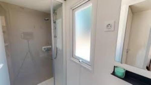 La salle de bains est pourvue d'une douche en verre et d'une fenêtre. dans l'établissement DC - Le Savina, 2 Ch, 2 sdb, confort et détente, proche Montpellier et Palavas, à Lattes