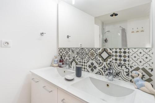 une salle de bain avec un lavabo et un miroir dans l'établissement Le Renoir - Maison au calme à 20min de Nantes, à Nantes