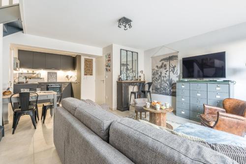 un salon avec un canapé et une table dans l'établissement Le Renoir - Maison au calme à 20min de Nantes, à Nantes