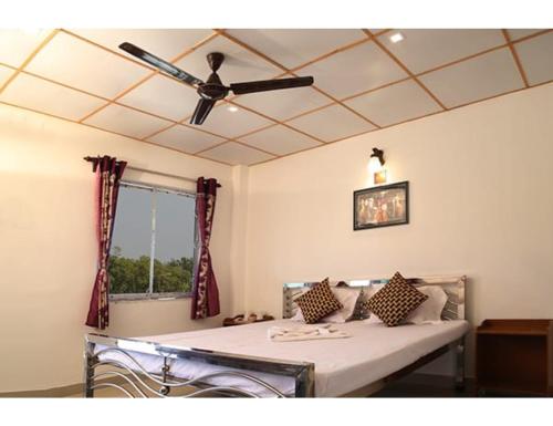 Camera con letto e ventilatore a soffitto. di Sundarban Wild Camp, Dayapur, WB a Japur
